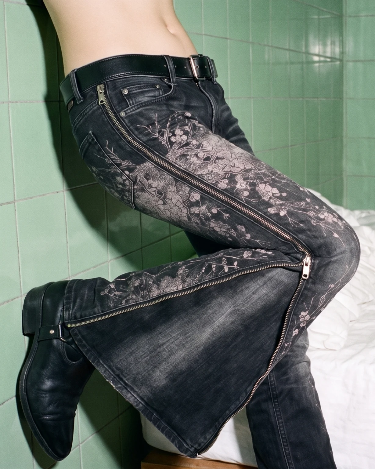 K03 KAI mid rise convertible jean, leg raised against green tiles, the full-length zip open down the outside of the leg